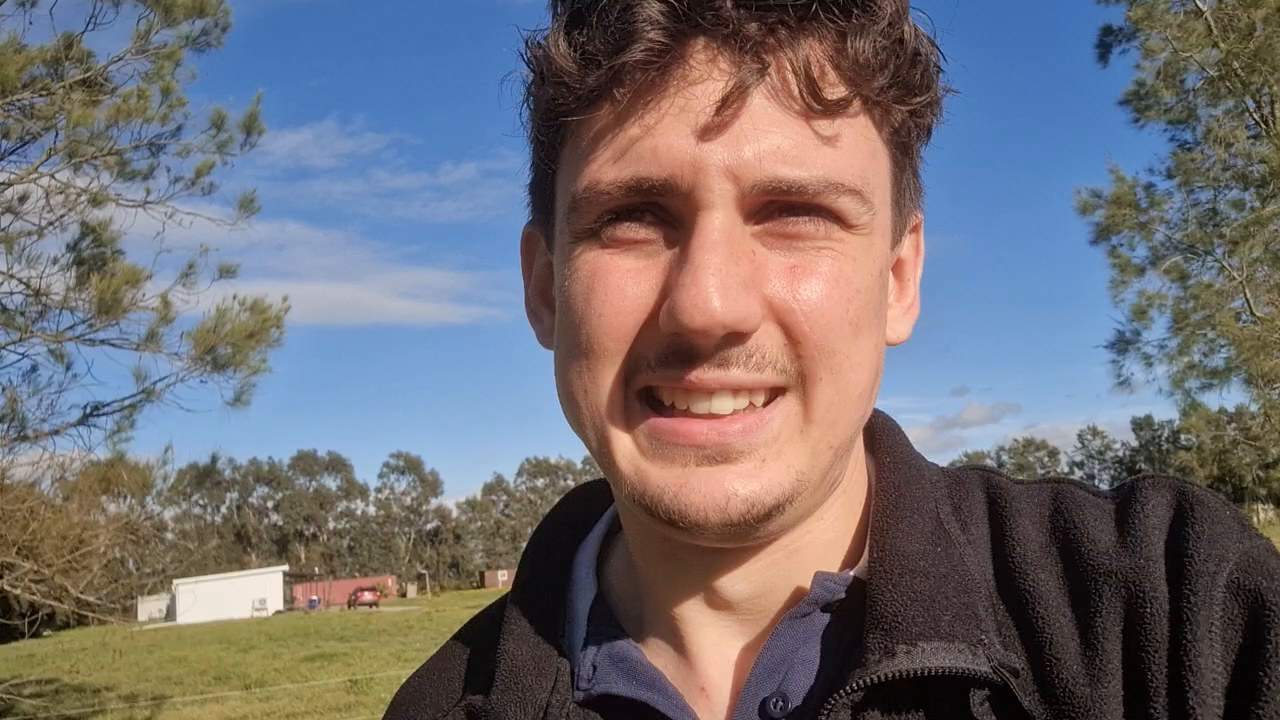 Stanley Kunz erzählt unter hohen Bäumen auf einer Weide in Uruguay in die Kamera.